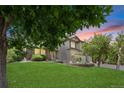 Beautiful home featuring a lush green lawn, mature trees, and an inviting exterior at 8725 Meadowlark Cir, Highlands Ranch, CO 80126