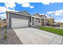 Single-Gathering home featuring a front porch, two car garage, and extended driveway at 770 N Deer Park St, Watkins, CO 80137