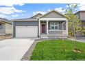 Inviting single-Gathering home showcasing a garage and a quaint covered porch area at 770 N Deer Park St, Watkins, CO 80137