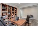 A well-organized home office with hardwood floors, built-in bookcase, and lots of light at 6899 Petunia Pl, Castle Rock, CO 80108