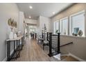Hallway view features wood flooring, stylish decor, and an open view to the living areas at 7010 Homeplace Pt, Castle Rock, CO 80108