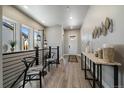 Bright hallway with wood floors, artful decor, and staircase at 7010 Homeplace Pt, Castle Rock, CO 80108