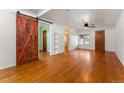 Bright living room with hardwood floors, ceiling fan, and sliding barn door at 2515 Ames St, Edgewater, CO 80214