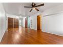 Open-concept living room with wood floors, ceiling fan, and white walls at 2515 Ames St, Edgewater, CO 80214