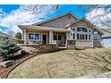 Inviting back exterior featuring a cozy porch with brick pillars and seating area, and lots of natural light at 1853 S Marshall Cir, Lakewood, CO 80232