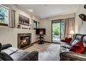 Relaxing living room with a stone fireplace and a sliding glass door to the backyard at 34 Highfield Trl # 112, Breckenridge, CO 80424