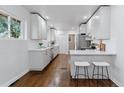 Bright kitchen featuring white cabinets, stainless steel appliances, and hardwood floors at 4003 Federal Blvd, Denver, CO 80211