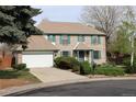 Inviting two-story brick home with a well-manicured front yard and an attached two-car garage at 12107 E Vassar Dr, Aurora, CO 80014