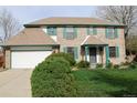 Classic brick home with green trim, an attached garage, and established landscaping at 12107 E Vassar Dr, Aurora, CO 80014