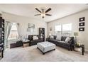 Bright living room with a ceiling fan and multiple windows offering plenty of natural light at 1063 Gianna Ave, Fort Lupton, CO 80621