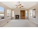 Bright living room featuring a fireplace, vaulted ceilings, a ceiling fan, and multiple windows at 17086 E 106Th Ave, Commerce City, CO 80022