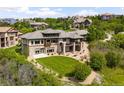 Back exterior of an impressive home, showcasing a manicured lawn and hillside views at 12775 Horizon Trl, Castle Pines, CO 80108