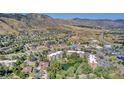 Elevated view of apartment buildings, green foliage and community pond against a mountain backdrop at 1150 Golden Cir # 409, Golden, CO 80401