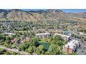 Aerial view of apartment buildings surrounded by mature trees and foliage with a small pond in the center at 1150 Golden Cir # 409, Golden, CO 80401