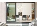 Open dining area with modern light fixture, dark metal chairs, and sliding glass doors at 1241 S Garfield St, Denver, CO 80210