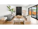 Bright living room featuring a fireplace, sleek furniture, light wood floors, and access to the outside patio at 1241 S Garfield St, Denver, CO 80210