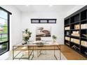 Office space featuring a glass desk, black bookshelf, and a large window at 1241 S Garfield St, Denver, CO 80210
