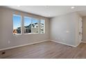 Open living space featuring wood floors, neutral paint, and large windows with neighborhood views at 1525 E 3Rd Ave, Longmont, CO 80501