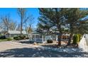 Quaint blue house with a covered porch, mature trees, and rock landscaping at 4196 S Pennsylvania St, Englewood, CO 80113