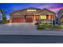 Inviting front exterior with a well-manicured lawn, a three-car garage, covered porch, and warm exterior paint colors at 1100 Columbine Way, Erie, CO 80516