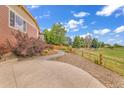 The home boasts a beautiful side yard, featuring a curved walkway and meticulously arranged landscaping with rock and natural wood accents at 1100 Columbine Way, Erie, CO 80516