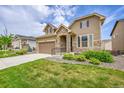Attractive two-story home featuring stone accents, an attached garage and lush green lawn at 6335 E 143Rd Dr, Thornton, CO 80602