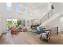 Bright living room boasting a soaring ceiling, large windows, and a staircase with decorative wrought iron railings at 9151 E Harvard Ave, Denver, CO 80231
