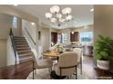Cozy dining room with a round table, chandelier, and hardwood floors, near the kitchen at 7887 Vallagio Ln, Englewood, CO 80112