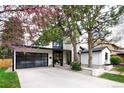 Modern home showcasing a stone facade, black trim, and a black framed glass garage door at 62 Jasmine St, Denver, CO 80220