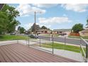 A view of the front of a house from a wood porch with metal railings at 1436 S Yates St, Denver, CO 80219