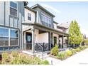Charming home with a cozy front porch, showcasing stylish architecture and well-maintained landscaping at 5025 Central Park Blvd, Denver, CO 80238
