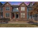 Charming brick townhome with a colorful door and lovely landscaped front yard at 8381 E 29Th Ave, Denver, CO 80238