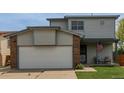 Two-story home with neutral siding, two car garage, and a cozy covered porch at 6119 Zenobia Ct, Arvada, CO 80003