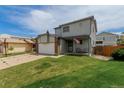 Inviting two-story home with a well-manicured lawn and a two-car garage at 6119 Zenobia Ct, Arvada, CO 80003