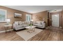 Cozy living room features hardwood floors, comfortable seating, and neutral paint at 6119 Zenobia Ct, Arvada, CO 80003