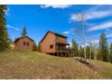Scenic exterior of mountain home with wood siding and inviting deck overlooking lush trees at 33606 Gap Rd, Golden, CO 80403