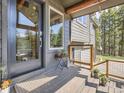 Stylish porch featuring a glass door, wood railings and potted plants at 32663 Donna Dr, Conifer, CO 80433