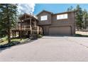 Two-story home with a two-car garage, wood exterior and nicely maintained front yard at 32663 Donna Dr, Conifer, CO 80433