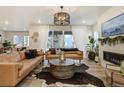 Bright living room featuring hardwood floors, modern furnishings, and a decorative fireplace at 6950 Hidden Cove Ct, Castle Pines, CO 80108