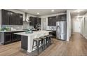 Stunning kitchen with large island, stainless steel appliances, and abundant dark wood cabinetry at 1677 Meagan Way, Erie, CO 80516