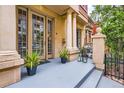 Inviting front porch with stone columns and potted plants, creating a warm and welcoming entrance at 1950 N Logan St # 108, Denver, CO 80203