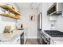 Modern kitchen with stainless steel appliances, white cabinets, and granite countertops at 525 Jackson St # 303, Denver, CO 80206