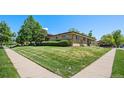 Beautifully landscaped lawn surrounds a single-story brick home with a manicured hedge and mature trees at 2501 E Arkansas Ave, Denver, CO 80210