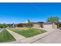Ranch home with lush front lawn, detached garage, and mature trees showcasing a well-maintained property at 2501 E Arkansas Ave, Denver, CO 80210