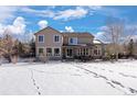Snow-covered backyard with a view of the house and a patio area at 1021 Neptunite Pl, Castle Rock, CO 80108