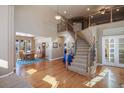 Grand two-story entryway with hardwood floors, curved staircase, and views to dining room at 1021 Neptunite Pl, Castle Rock, CO 80108