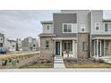 Modern townhome featuring mixed siding, stone accents, and a charming front porch offering stylish curb appeal at 12345 Festival Ln, Thornton, CO 80241