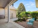 A cozy back patio features a small outdoor dining set and a charming gravel area surrounded by lush greenery at 10631 Clarke Farms Dr, Parker, CO 80134