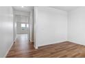 Open-concept living area with bright white walls and wood-look flooring at 27574 E Byers Ave, Aurora, CO 80018