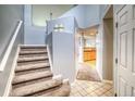 Light and bright entryway features beautiful stairs, tile floors, and access to the kitchen at 23070 York Ave, Parker, CO 80138